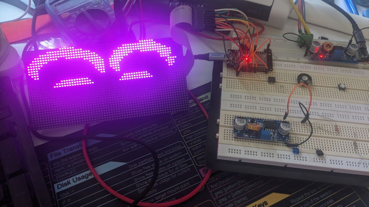 Panel displaying a smile connected to a esp32 with loose wires